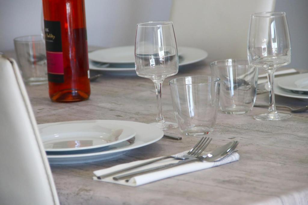 a table with plates and wine glasses on it at SeaHomes Vacations, BEACH&POOL, in Fenals Beach in Lloret de Mar
