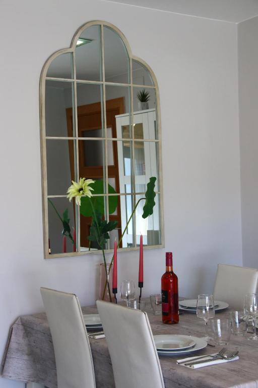 a dining room with a table with chairs and a mirror at SeaHomes Vacations, BEACH&POOL, in Fenals Beach in Lloret de Mar