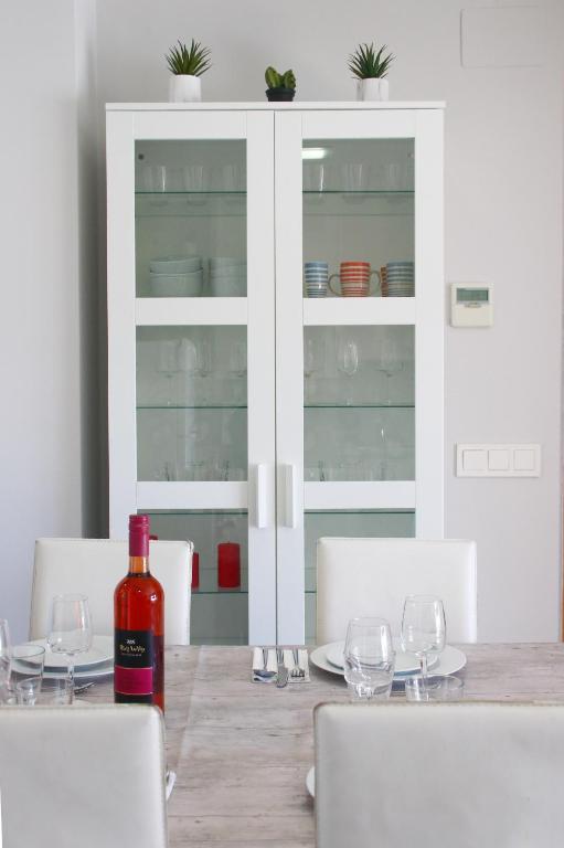 a bottle of wine sitting on a table with wine glasses at SeaHomes Vacations, BEACH&POOL, in Fenals Beach in Lloret de Mar