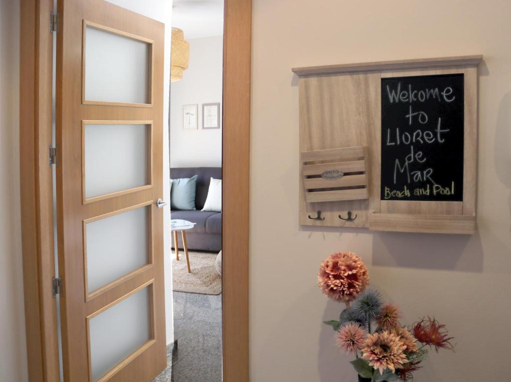 a door to a living room with a sign on the wall at SeaHomes Vacations, BEACH&POOL, in Fenals Beach in Lloret de Mar