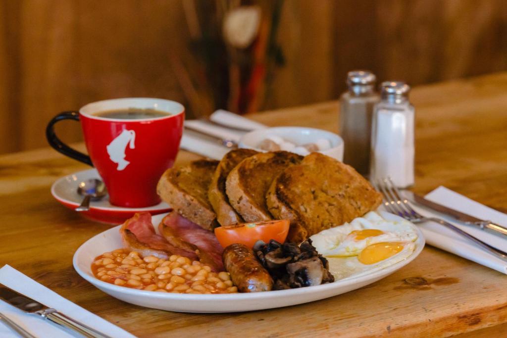 a plate of breakfast food with a cup of coffee at The Griffin Belle Hotel Vauxhall in London