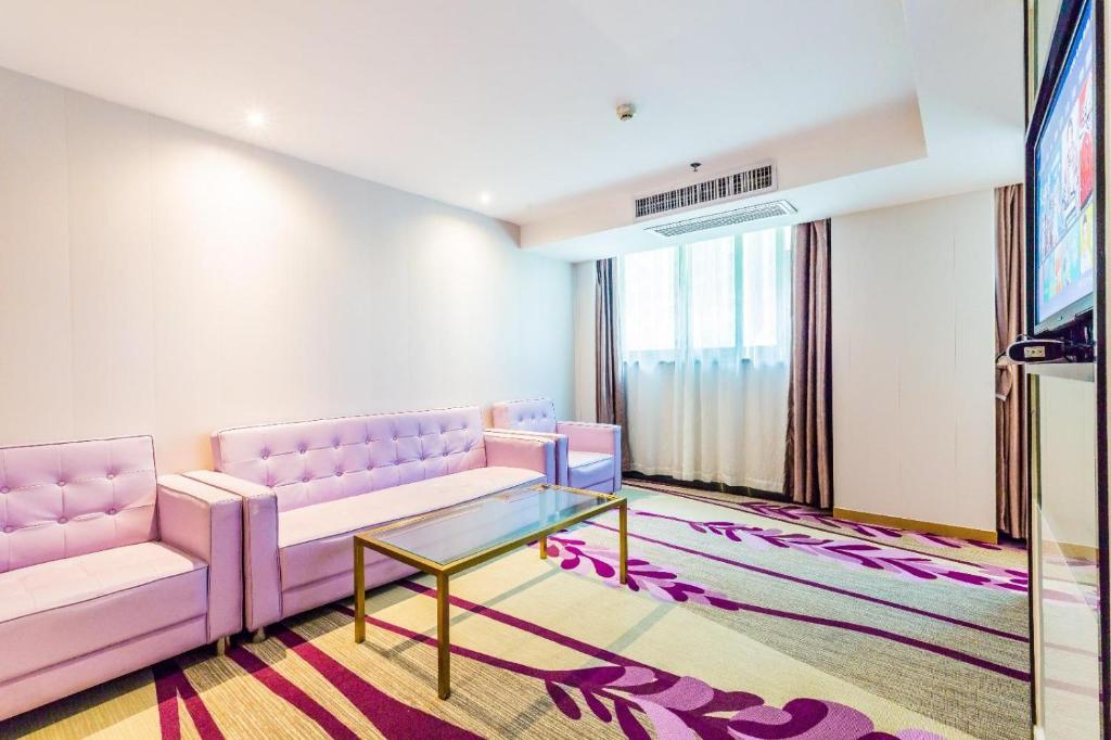 a living room with a pink couch and a glass table at Lavande Hotel Foshan Shunde Ronggui in Shunde