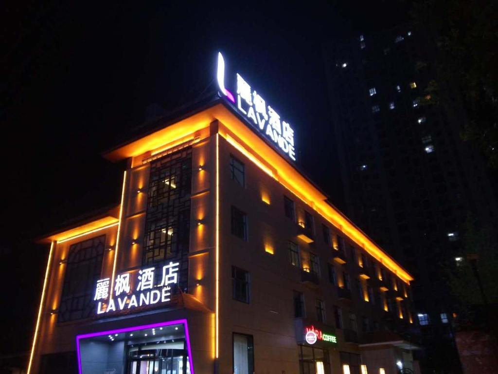 un bâtiment avec un panneau en haut de celui-ci la nuit dans l'établissement Lavande Hotel Xi'an Wenjing Road, à Xi'an