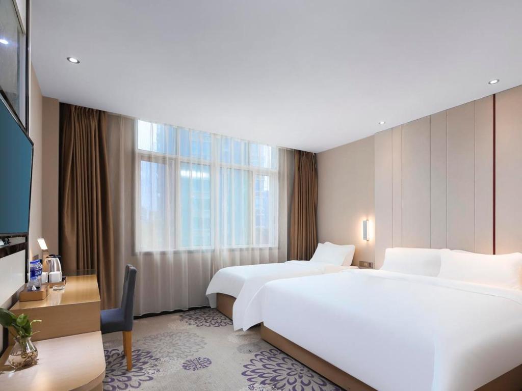 a hotel room with two beds and a large window at Lavande Hotels·Nanjing Dachang Metro Station in Nanjing