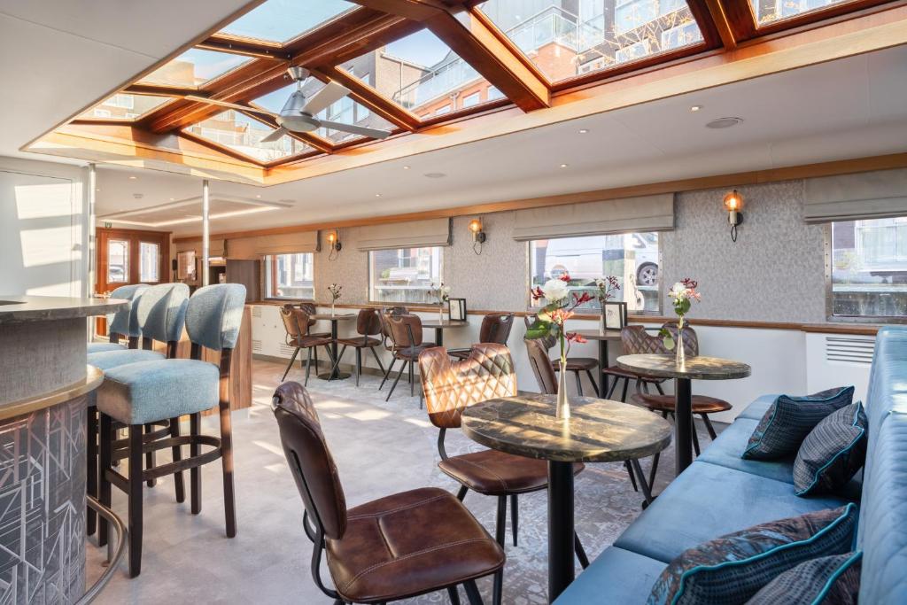 
a living room filled with furniture and a large window at Boat Hotel Merlijn in Dordrecht
