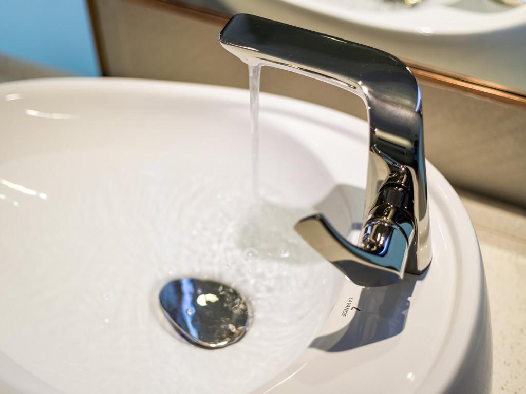 a sink with water running from a faucet at Lavande Hotels·Guangzhou Fangcun Jiaokou Metro Station in Guangzhou