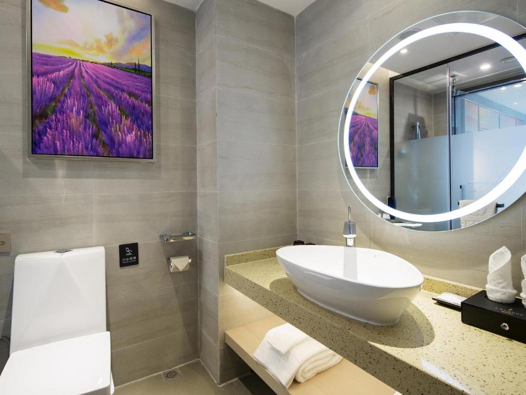 ein Bad mit einem Waschbecken und einem Spiegel in der Unterkunft Lavande Hotel Zhangjiajie Tianmenshan Dayongfucheng in Zhangjiajie