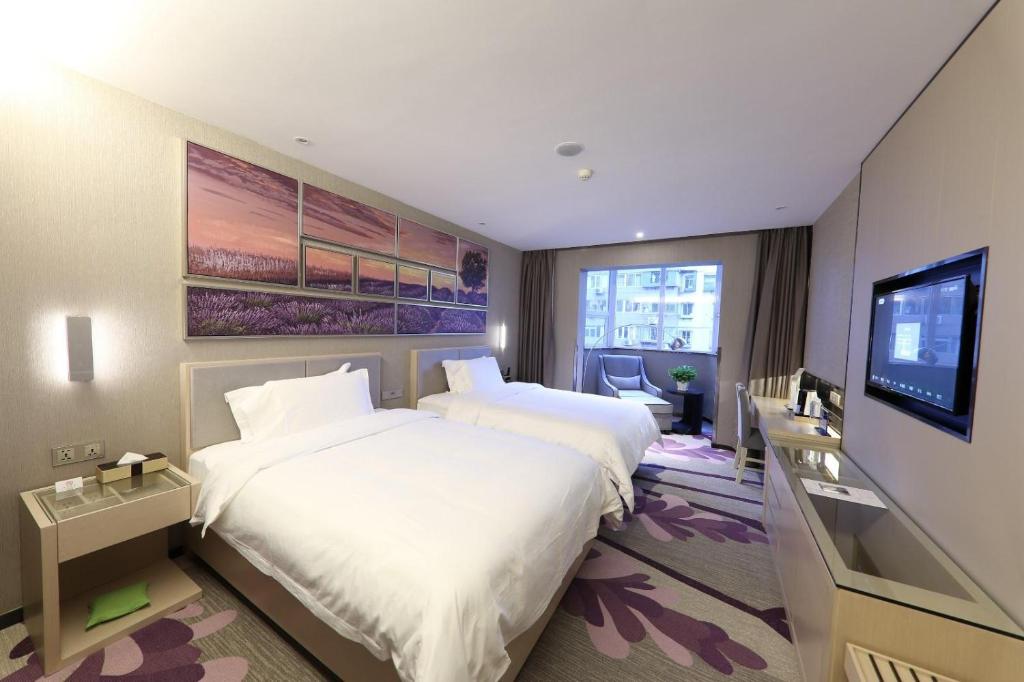 um quarto de hotel com duas camas e uma televisão de ecrã plano em Lavande Hotels·Beijing South Railway Station Yangqiao em Pequim