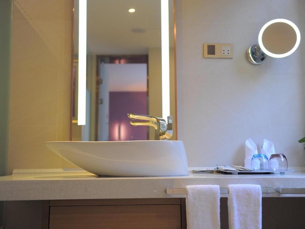 a bathroom with a sink and a mirror at Lavande Hotel Gulin railway station Shangzhi Alley in Guilin