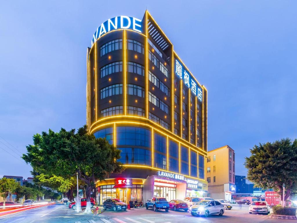 un edificio alto amarillo con coches estacionados frente a él en Lavande Hotels·Foshan Nanhai Dali New Metropolis en Foshan