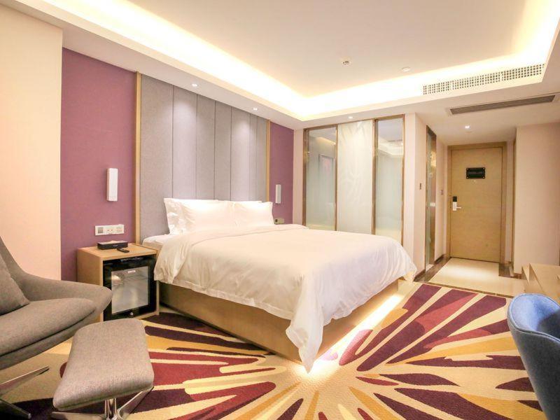 um quarto com uma cama, um sofá e uma cadeira em Lavande Hotels·Foshan Bijiang Light Rail Country Garden Headquarters em Guangzhou