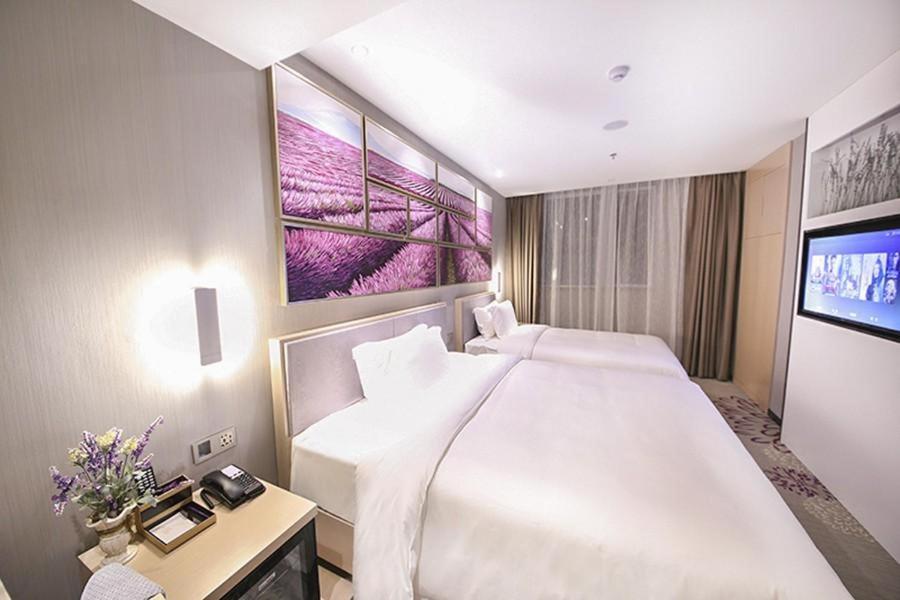 - une chambre avec un grand lit blanc et une télévision dans l'établissement Lavande Hotel Beijing Guanganmen Daguan Garden, à Pékin