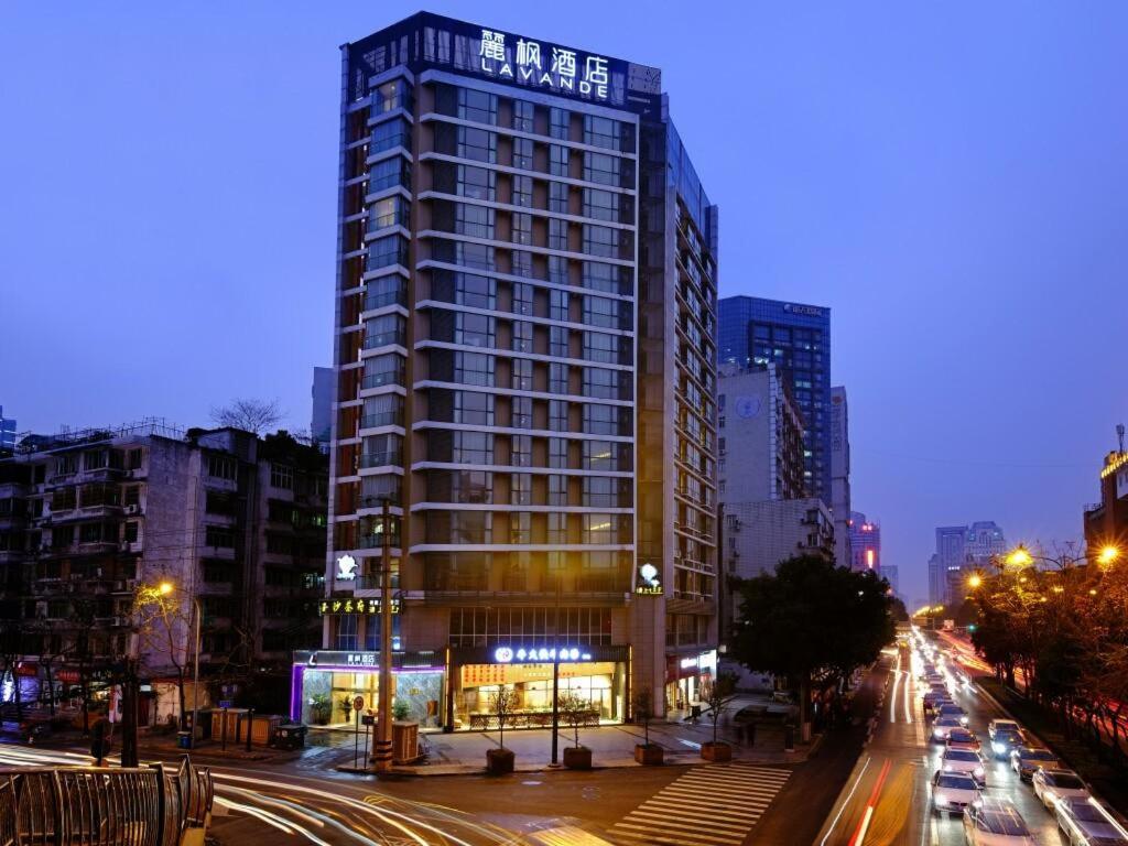 un edificio alto en una calle de la ciudad por la noche en Lavande Hotel Chengdu Chunxi Road en Chengdú