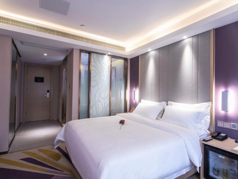 1 dormitorio con 1 cama blanca grande y TV en Lavande Hotel Suzhou Dushu Lake Gaojiao District, en Suzhou