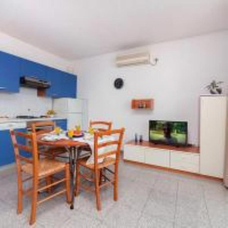 a dining room with a table and chairs and a tv at Apartment Villa Lidija in Lovran