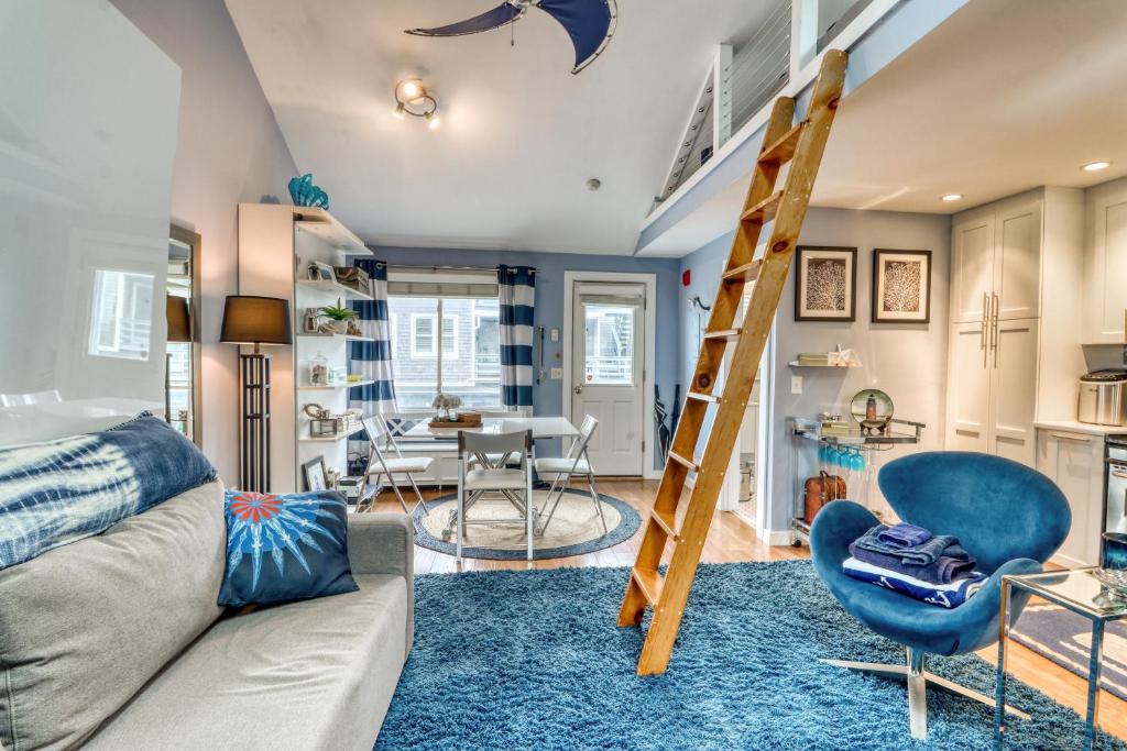 a living room with a couch and a ladder at Provincetown Waterfront Studio in Provincetown