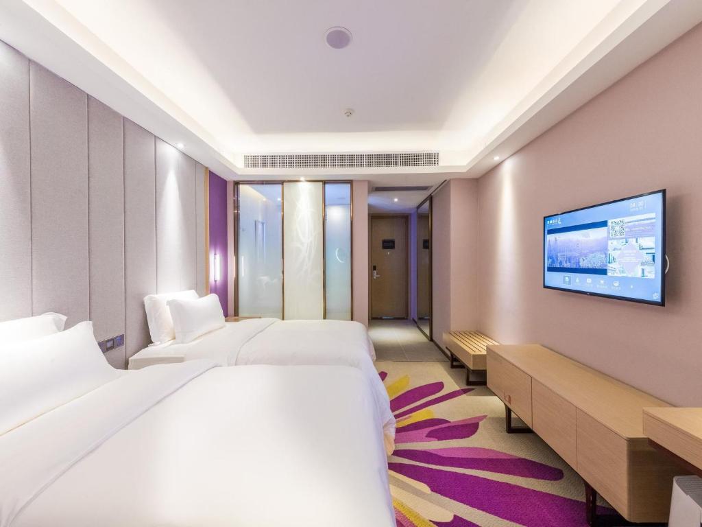 a hotel room with two beds and a flat screen tv at Lavande Hotels·Foshan Zhoucun Ligang Road Xunfenggang Metro Station in Foshan