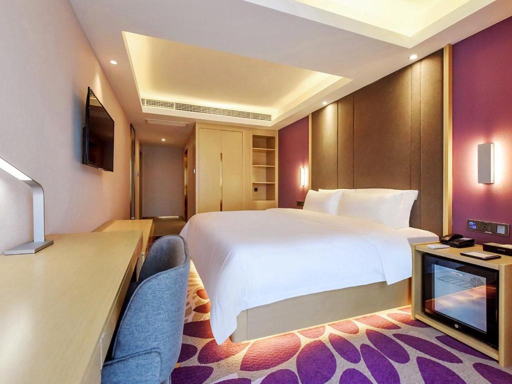 a hotel room with a large bed and a desk at Lavande Hotels·Chongqing Longtoushi North Railway Station in Chongqing
