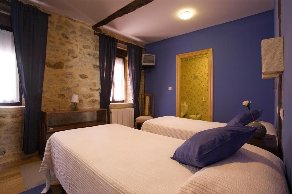 sypialnia z 2 łóżkami i niebieską ścianą w obiekcie Casa Rural Enkartada w mieście Sopuerta