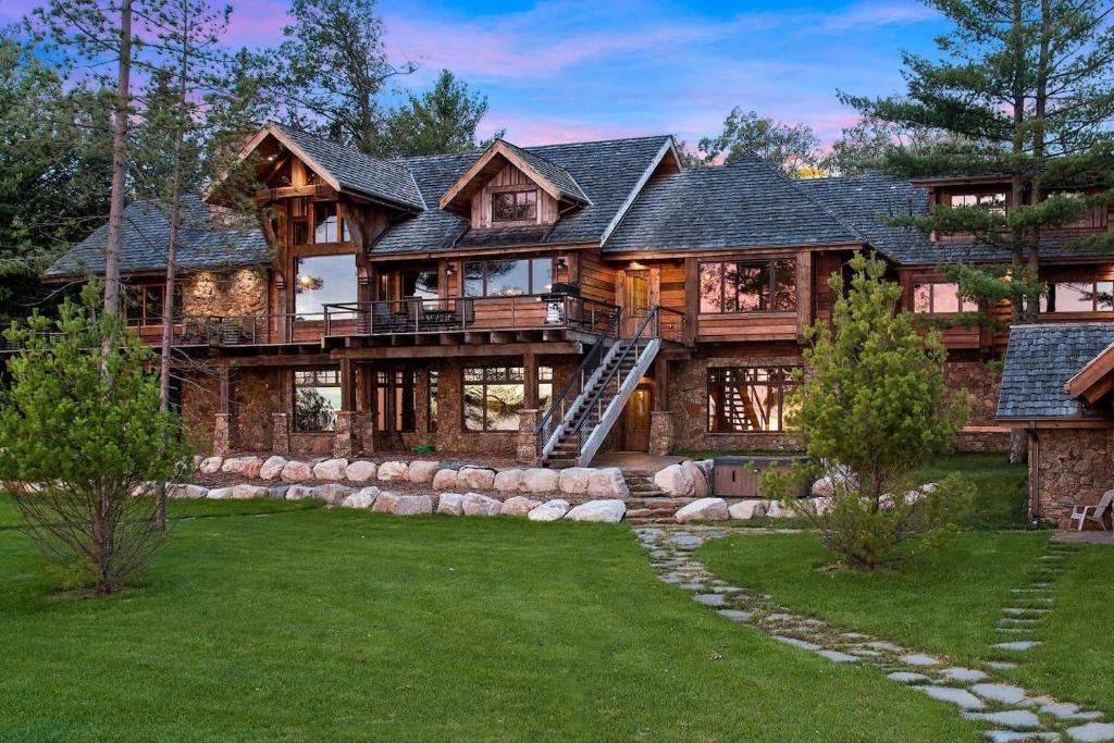 a large log home with a large deck at Gull Lakes Finest! Reclaimed Charm and Luxury in Lake Shore