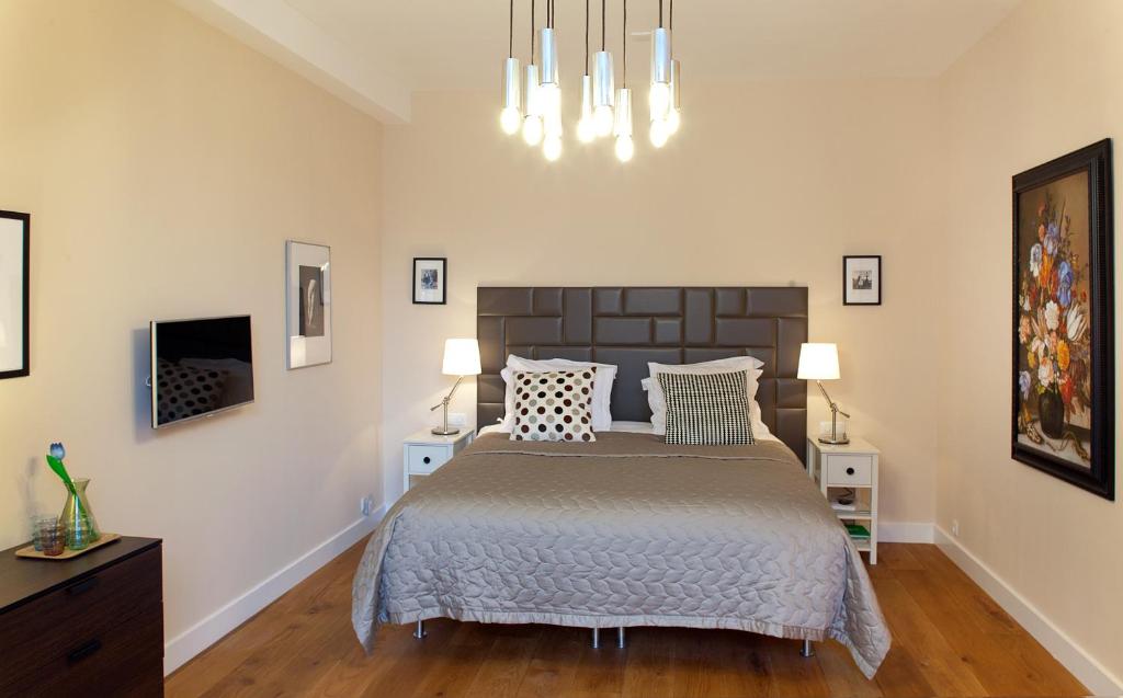 a bedroom with a large bed and a chandelier at Blue Tulip Amsterdam in Amsterdam