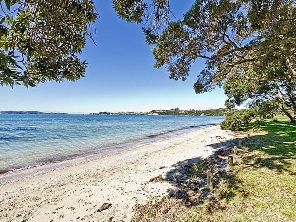 vistas a una playa con árboles y agua en Beachside at Snells - Snells Beach Apartment en Snells Beach