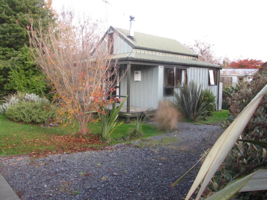 a small house in a yard with a tree at Miro Magic - Ohakune Holiday Home in Ohakune
