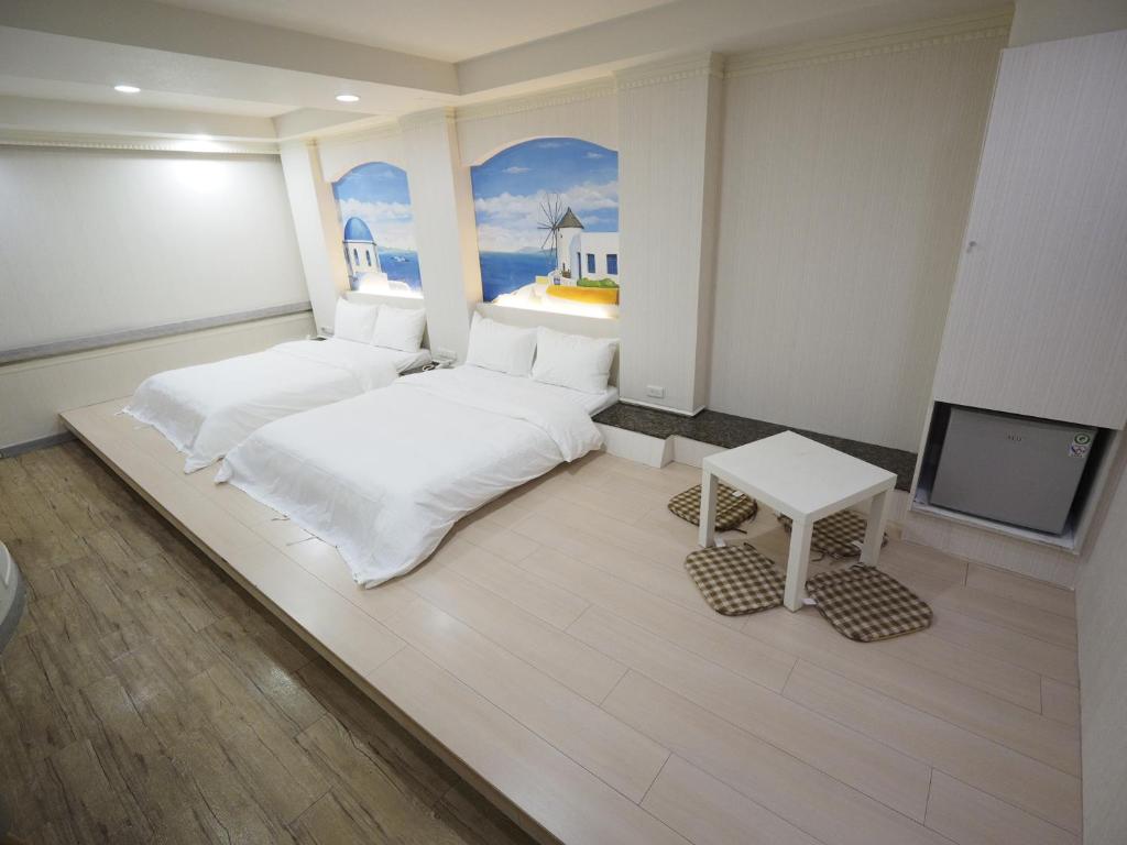 um quarto com 2 camas e uma televisão de ecrã plano em 合悅都會商旅 Heyue HOTEL em Hsinchu