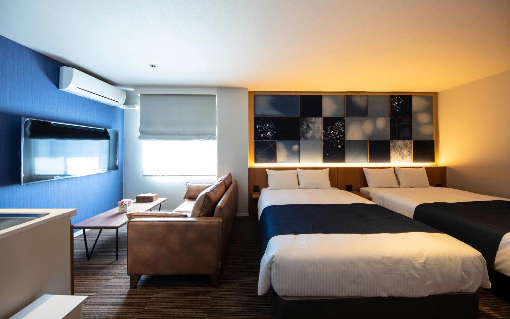 倉敷的住宿－GRAND BASE Kurashiki Chuo，酒店客房,设有两张床和一张沙发