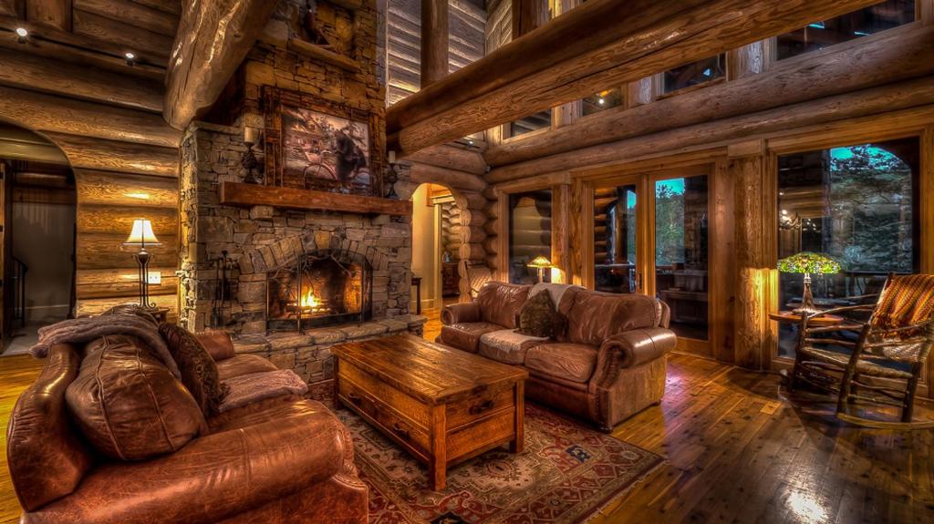 sala de estar con muebles de cuero y chimenea en Legend, en Ellijay