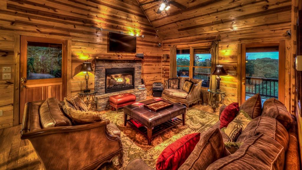 una sala de estar con muebles y chimenea en una cabaña de madera en Majestic Sunrise, en Blue Ridge