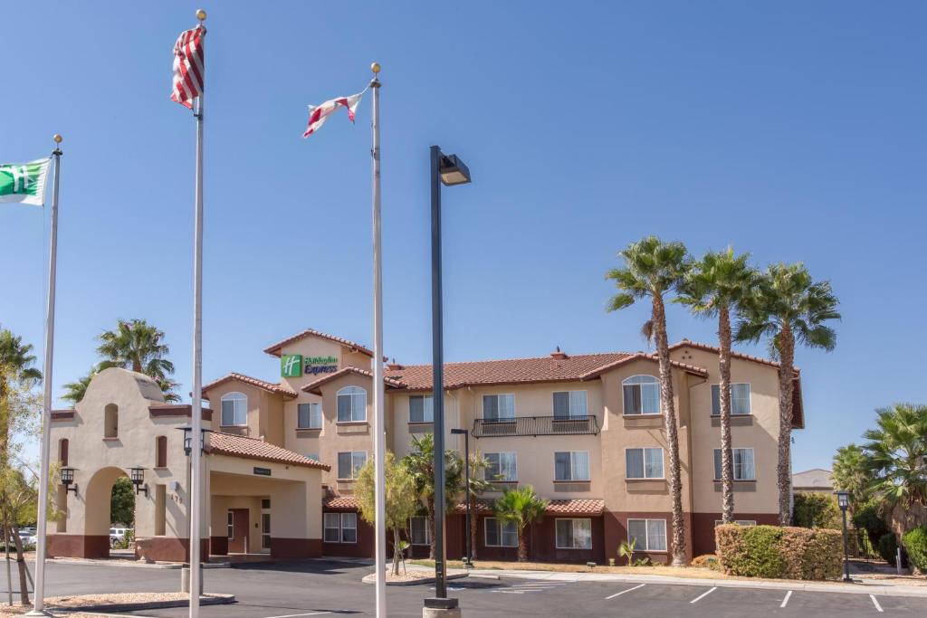 a hotel with palm trees in a parking lot at Holiday Inn Express Hotel & Suites Manteca, an IHG Hotel in Manteca