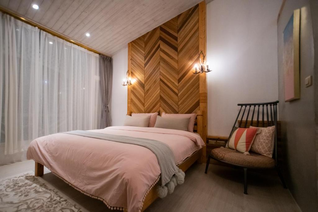 um quarto com uma cama grande e uma cadeira em QBE B&B em Nanwan