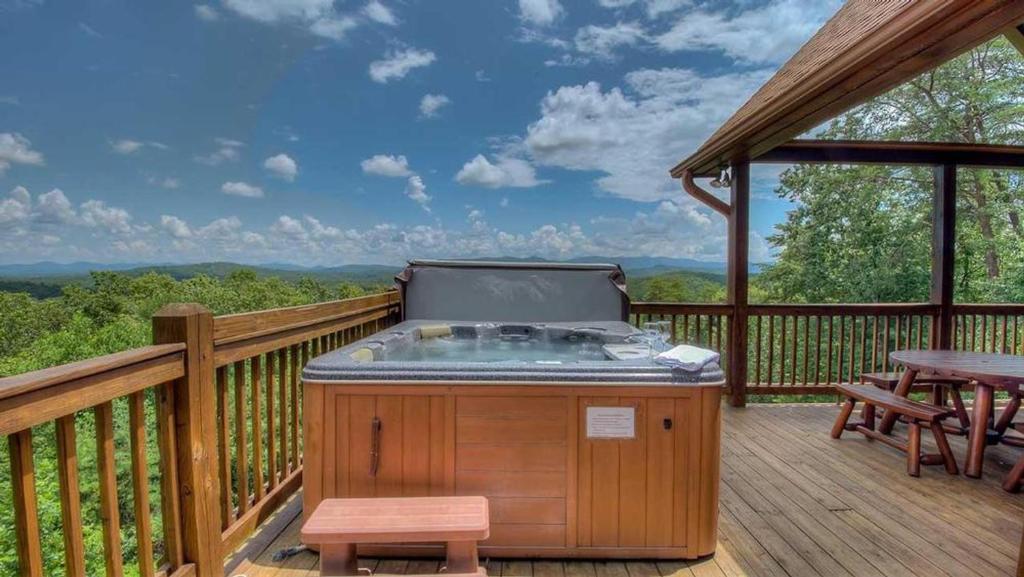 Un jacuzzi en una terraza con una mesa de picnic. en Panoramic Grace, en Blue Ridge