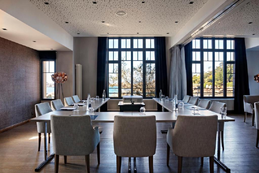 a conference room with tables and chairs and windows at Castel Beau Site in Perros-Guirec
