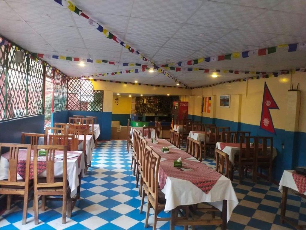 a restaurant with tables and chairs in a room at Best Hostel in Kathmandu