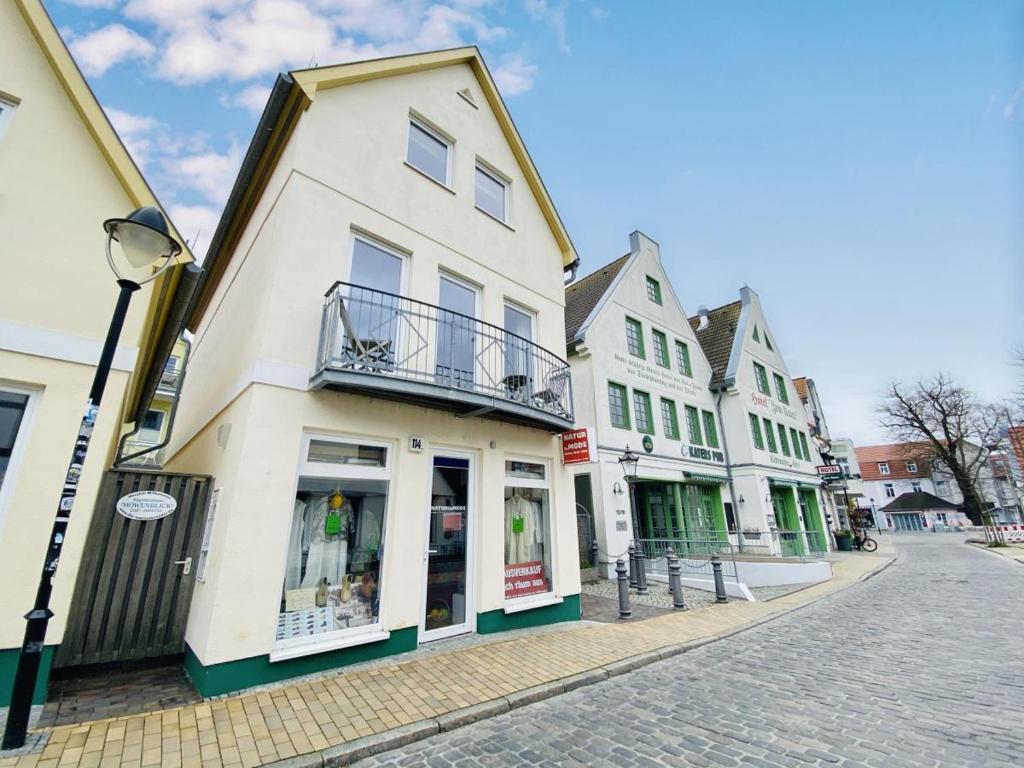 un groupe de bâtiments sur une rue pavée dans l'établissement Kapitänshaus Möwenblick, à Warnemünde