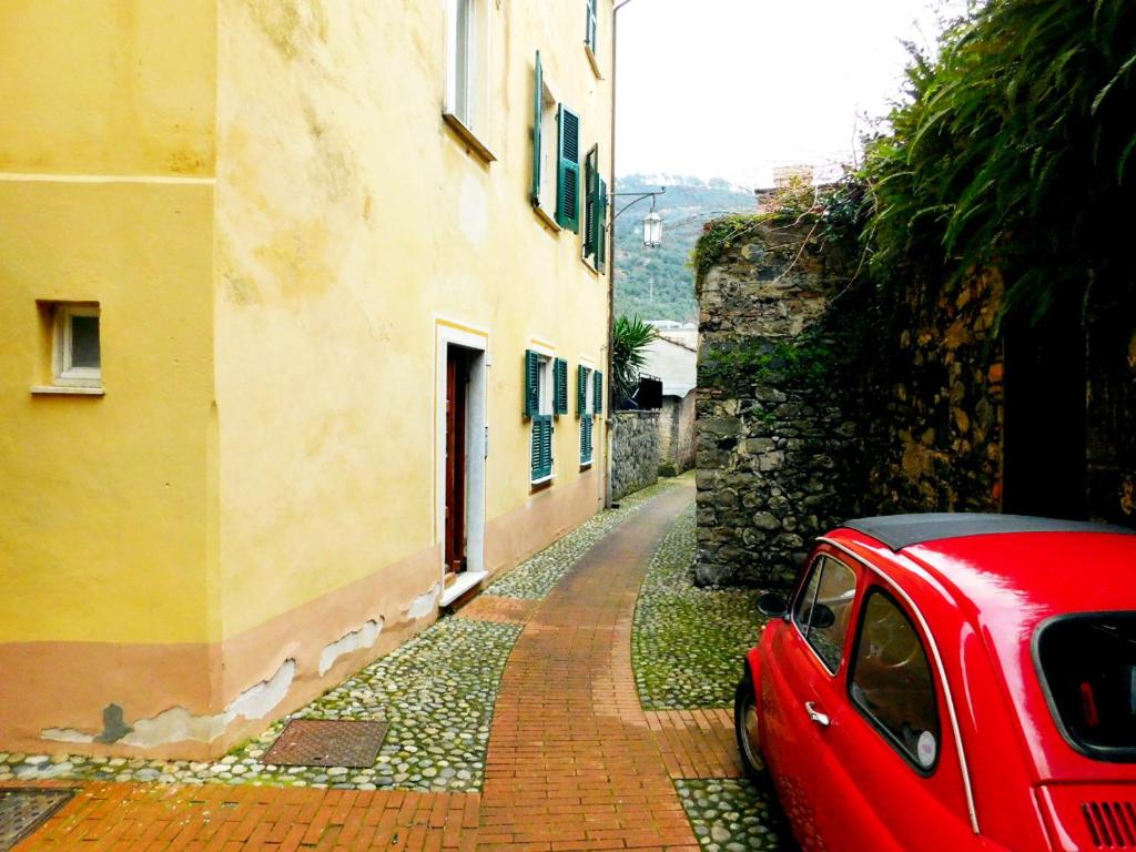 ein rotes Auto auf einer Backsteinstraße neben einem Gebäude in der Unterkunft Bellissima casa nel centro storico!!! in Levanto