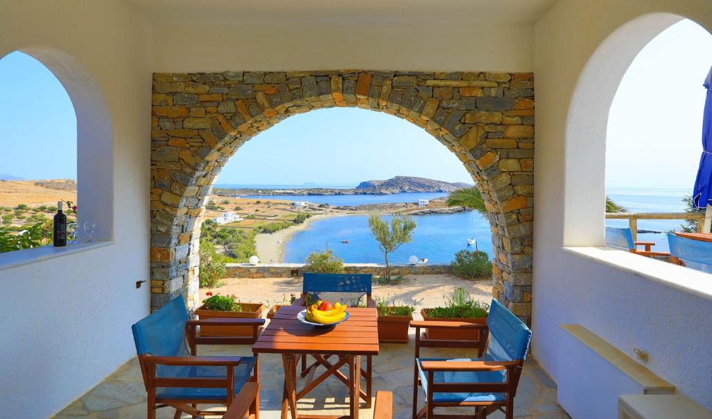 a dining room with an archway and a table and chairs at Armonia by Grispos Villas in Skhoinoussa