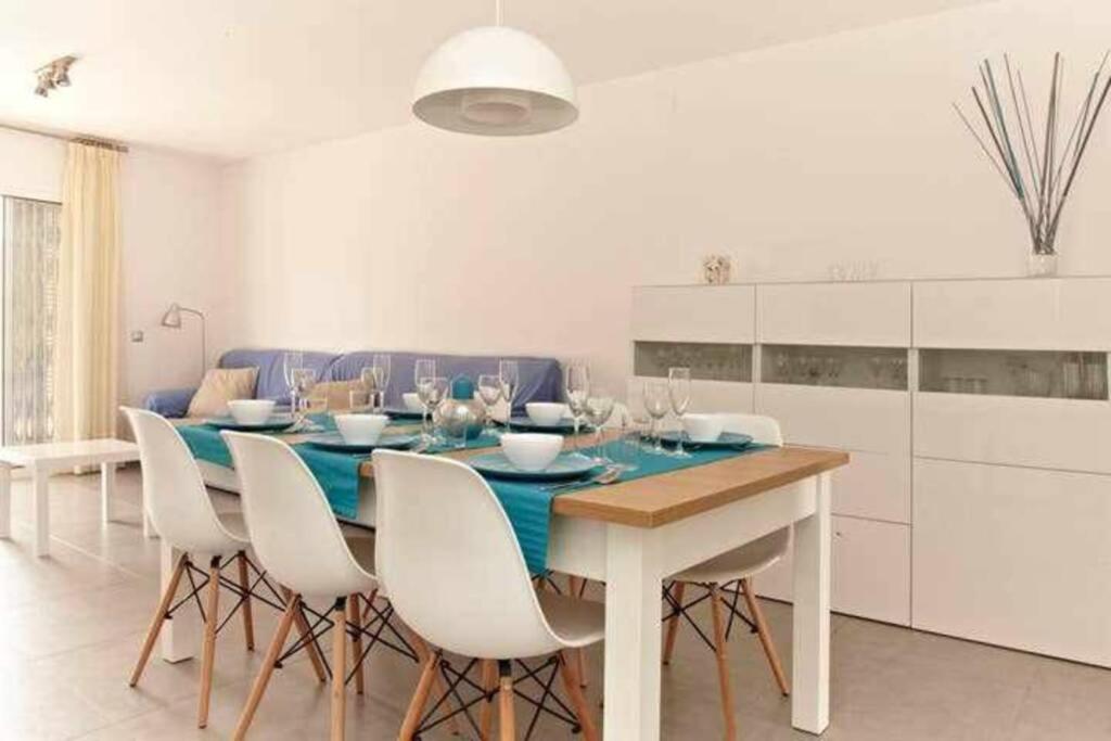a dining room with a blue table and white cabinets at Homing Cambrils 23 in Cambrils