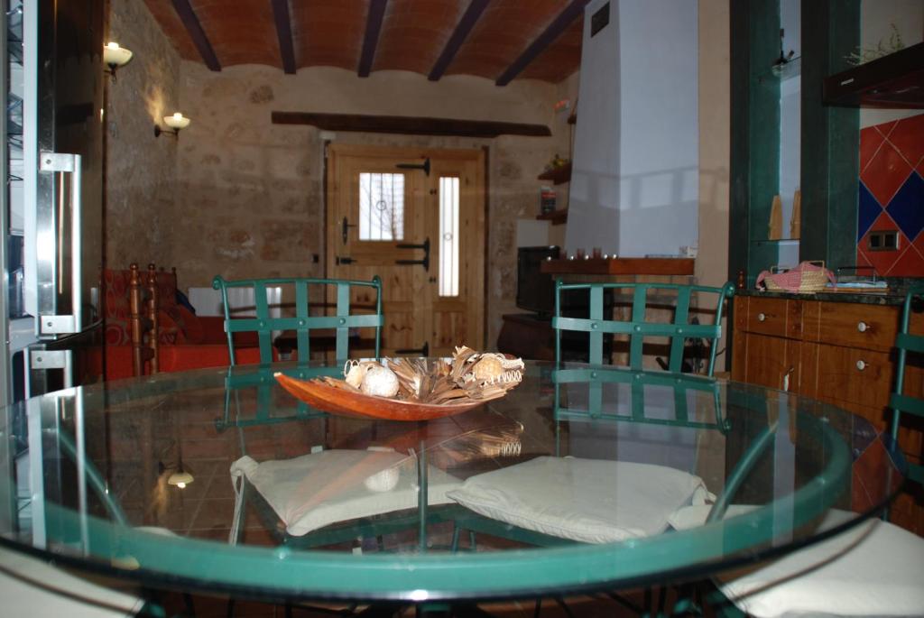 une table en verre avec des chaises et un bol en haut dans l'établissement Casa La Catalina III, à Beceite