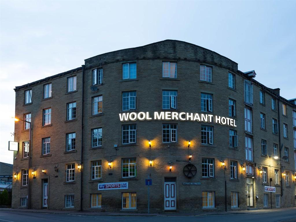 ハリファックスにあるWool Merchant Hotel HALIFAXの看板が貼られた大きなレンガ造りの建物