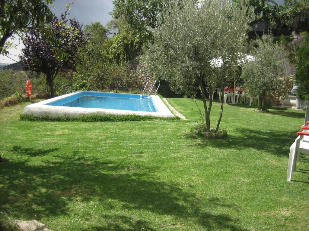 a swimming pool in a yard with green grass at Alojamiento Rural Mirador del Avellano in Alpujarra de la Sierra