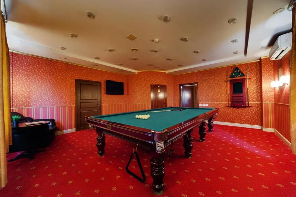 a pool table in a room with orange walls at Grand Peterhof Spa Hotel in Petergof