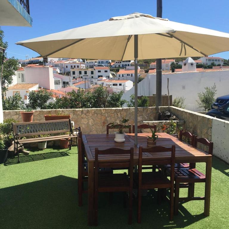 a wooden table with an umbrella on a roof at Carrapateira Lodge in Carrapateira