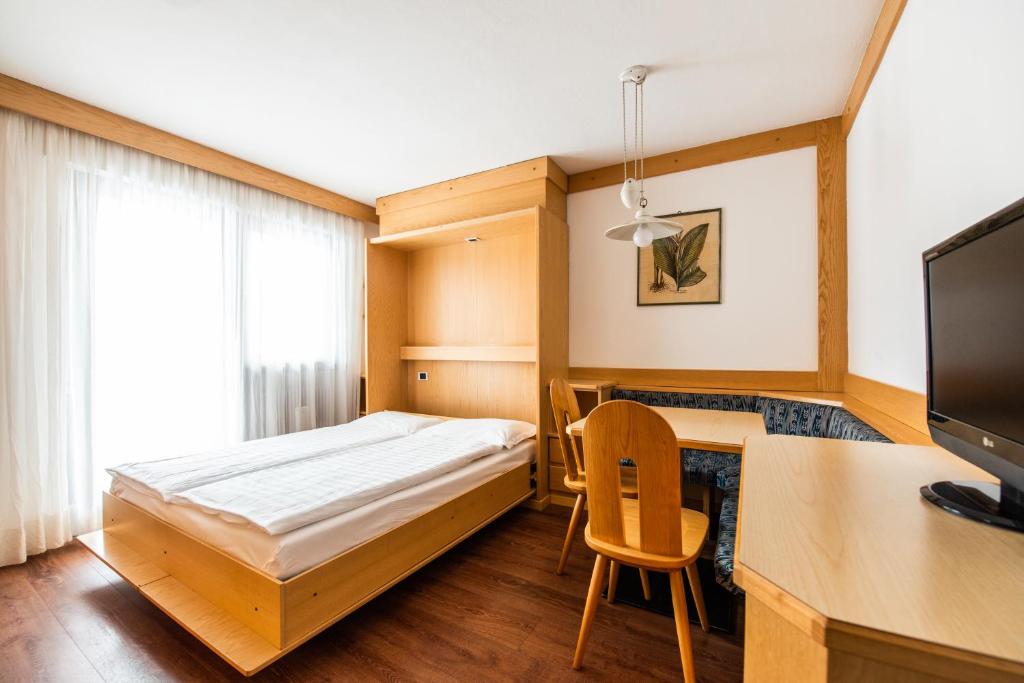 una camera con letto e scrivania con computer di Residence Contrin a Canazei