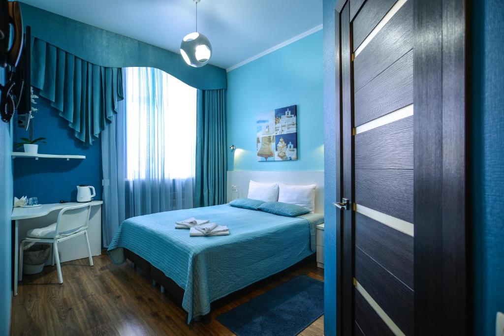 オムスクにあるMini-Otel Sovaの青いベッドルーム(ベッド1台、デスク付)