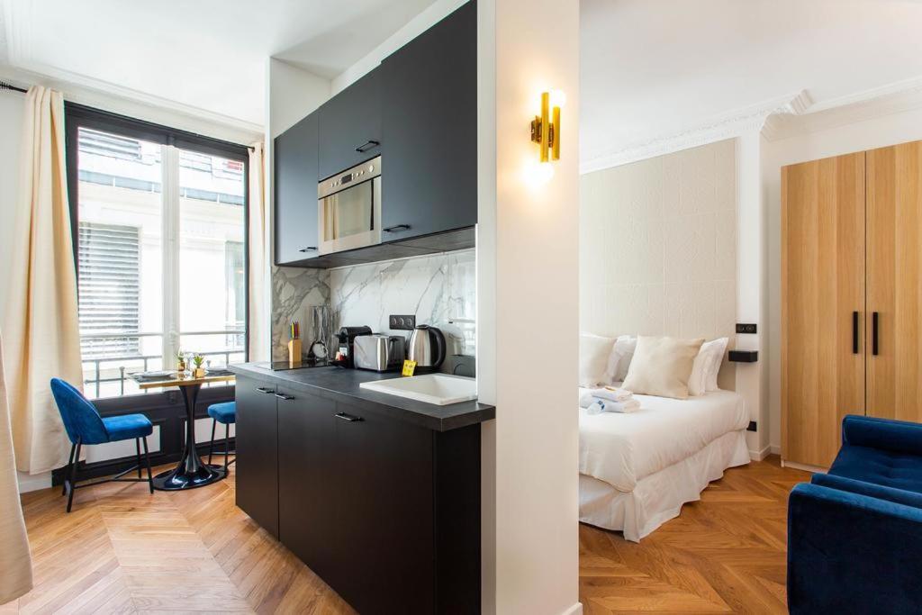 een keuken en een slaapkamer met een bed en een tafel bij CMG Champs Elysees - Boetie 5 in Parijs