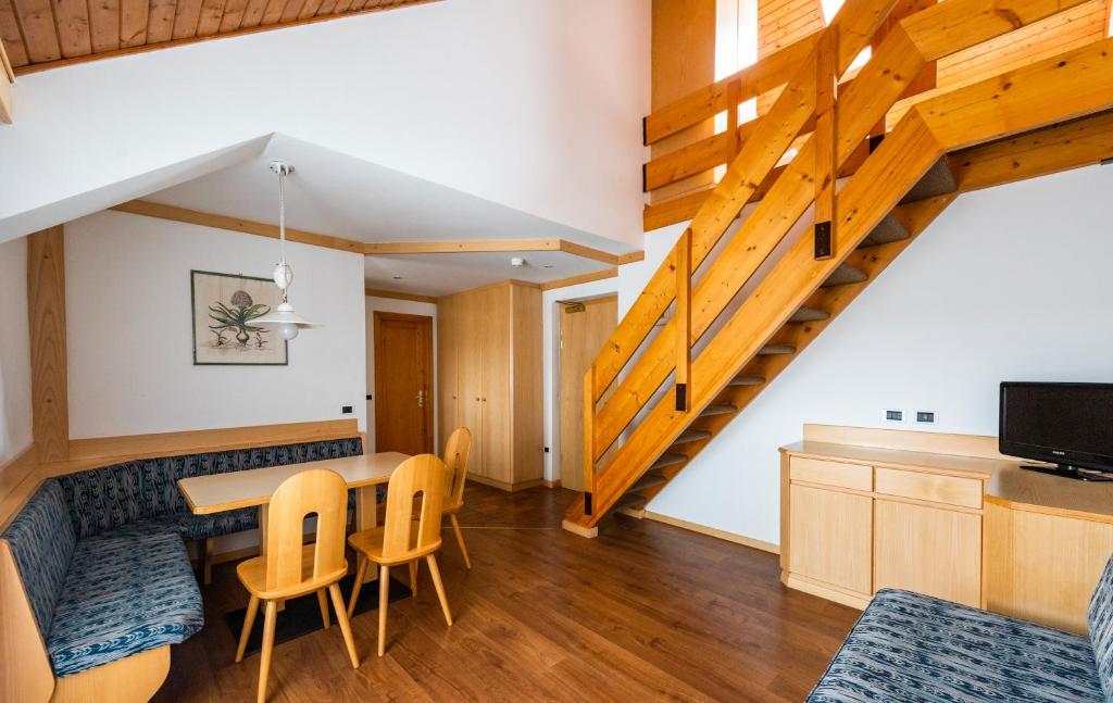 una cucina e una sala da pranzo con tavolo e sedie di Residence Contrin a Canazei