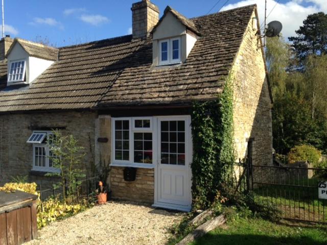 a small brick house with a white door at The Folly in Tetbury